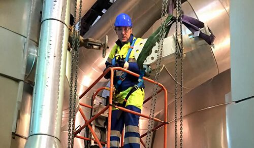 Travailleur équipé d’EPI évoluant sur une plate-forme en hauteur lors d’une formation à la sécurité au travail.